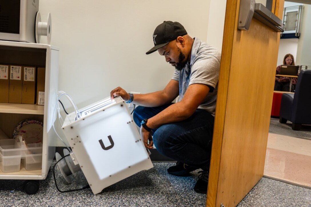 STAFFORD, Va. – Naval Surface Warfare Center Dahlgren Division (NSWCDD) IT specialist Eric Hayes sets up a 3D printer at the Academy of Technology and Innovation at the University of Mary Washington. NSWCDD donated 3D printers, a resin printer and 3D scanner materials to support the program’s students.