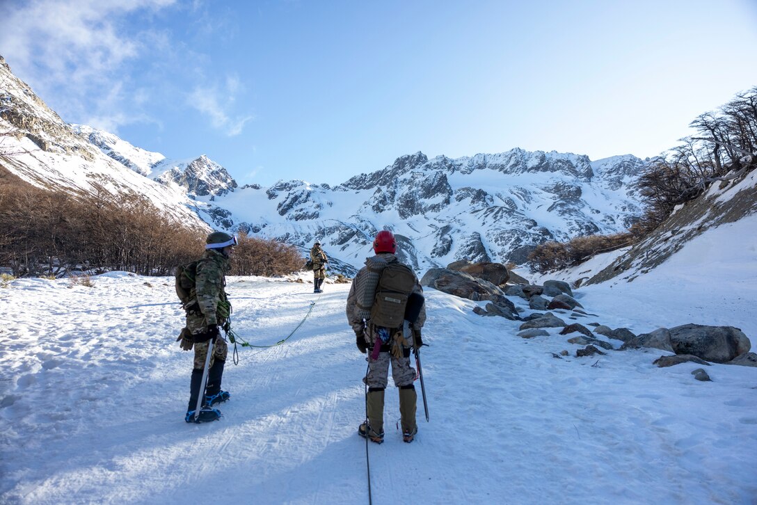 U.S. Marine Corps 1st Lt. Damon Crossland, with the Mountain Warfare Training Center, and Midshipman of Infantry Marines. (2nd Lt.) Isaias Diaz, a member of the Batallón de Infantería de Marina 5, look up at the peak of the mountain they are climbing, in Ushuaia, Argentina, Aug 13, 2025. This training creates opportunities for continued combined exercises with Argentine forces which aims to build upon the skills learned in these knowledge exchanges. (U.S. Marine Corps photo by Lance Cpl. Payton Goodrich)