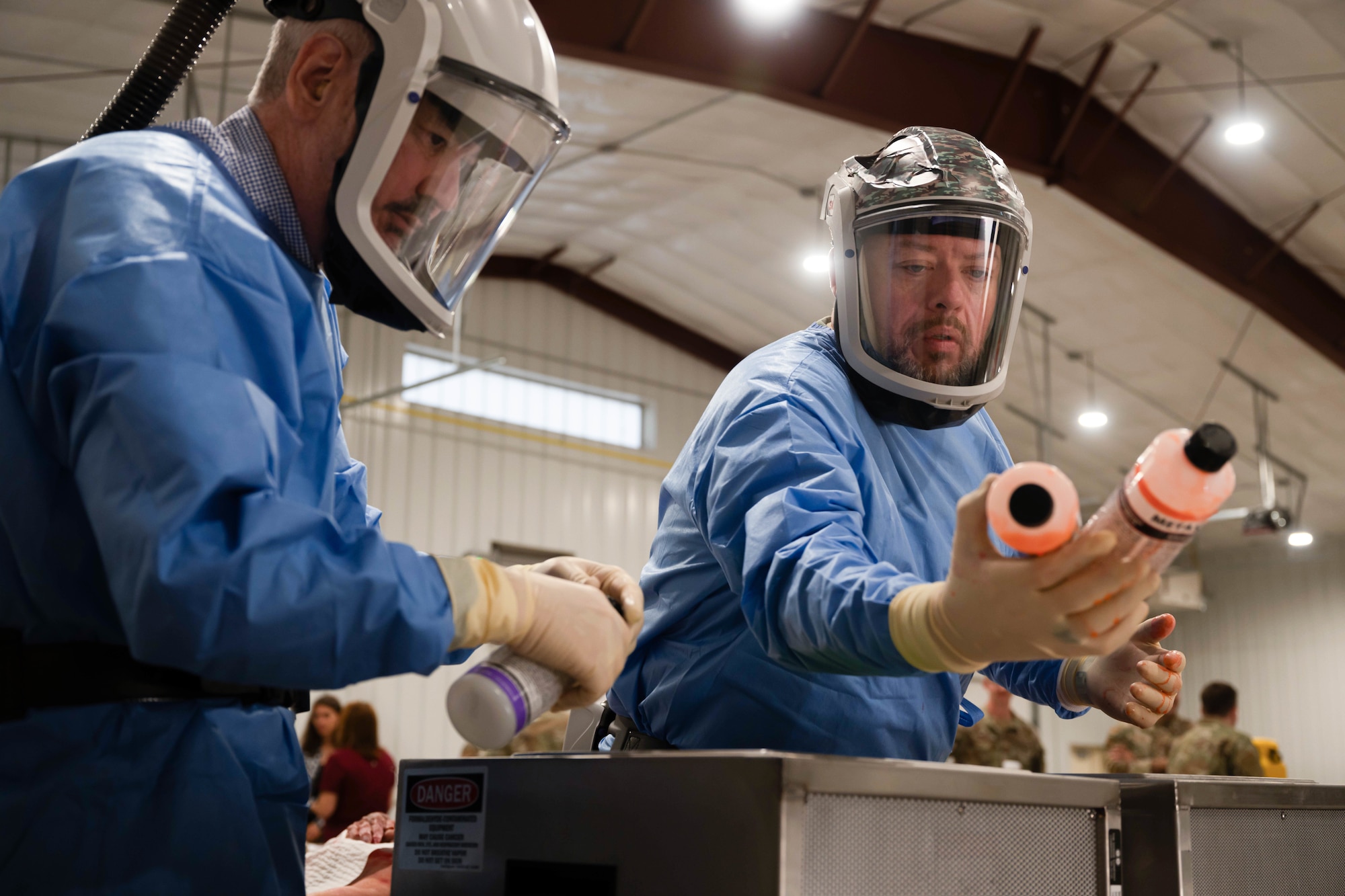 (left) Matthew McCloskey, Air Force Mortuary Affairs past conflicts and training, and (right) Matthew Metschke, AFMAO case management branch chief, prepare embalming materials for the AFMAO expeditionary mortuary constructed during annual exercise Northern Strike 25-2 at Grayling Army Air Field, Michigan, Aug. 10, 2025. AFMAO members established the exercise’s first expeditionary mortuary and instructed other branches' mortuary affairs personnel on how to do different operations within the exercise. (U.S. Air Force photo by Senior Airman Madeline Baisey)