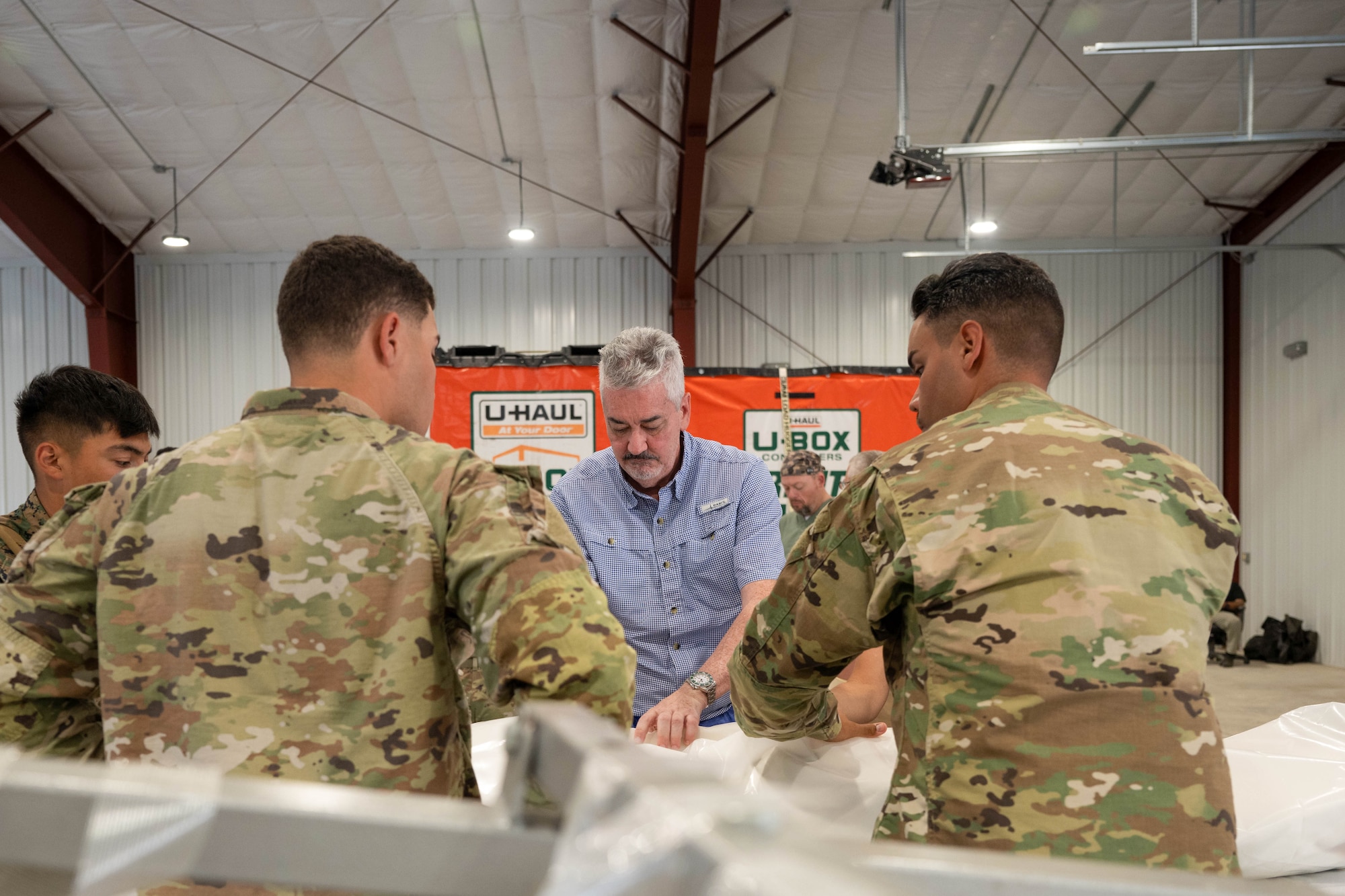 Matthew McCloskey, Air Force Mortuary Affairs past conflicts and training, instructs members of exercise Northern Strike 25-2 on how to complete a body wrap within AFMAO expeditionary mortuary at Grayling Army Airfield, Michigan, Aug. 10, 2025. NS 25-2 was the first time AFMAO has physically participated in the exercise. (U.S. Air Force photo by Senior Airman Madeline Baisey)