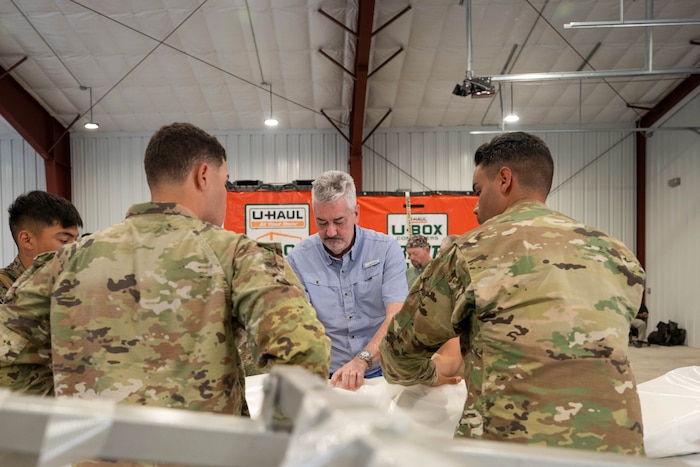 Matthew McCloskey, Air Force Mortuary Affairs past conflicts and training, instructs members of exercise Northern Strike 25-2 on how to complete a body wrap within AFMAO expeditionary mortuary at Grayling Army Airfield, Michigan, Aug. 10, 2025. NS 25-2 was the first time AFMAO has physically participated in the exercise. (U.S. Air Force photo by Senior Airman Madeline Baisey)