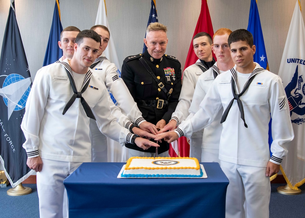 U.S. Marine Corps Lt. Gen. William Bowers, commanding general, Marine Corps Recruiting Command (center), cuts a cake with six of the honor graduates after pass-in-review onboard U.S. Navy Recruit Training Command.