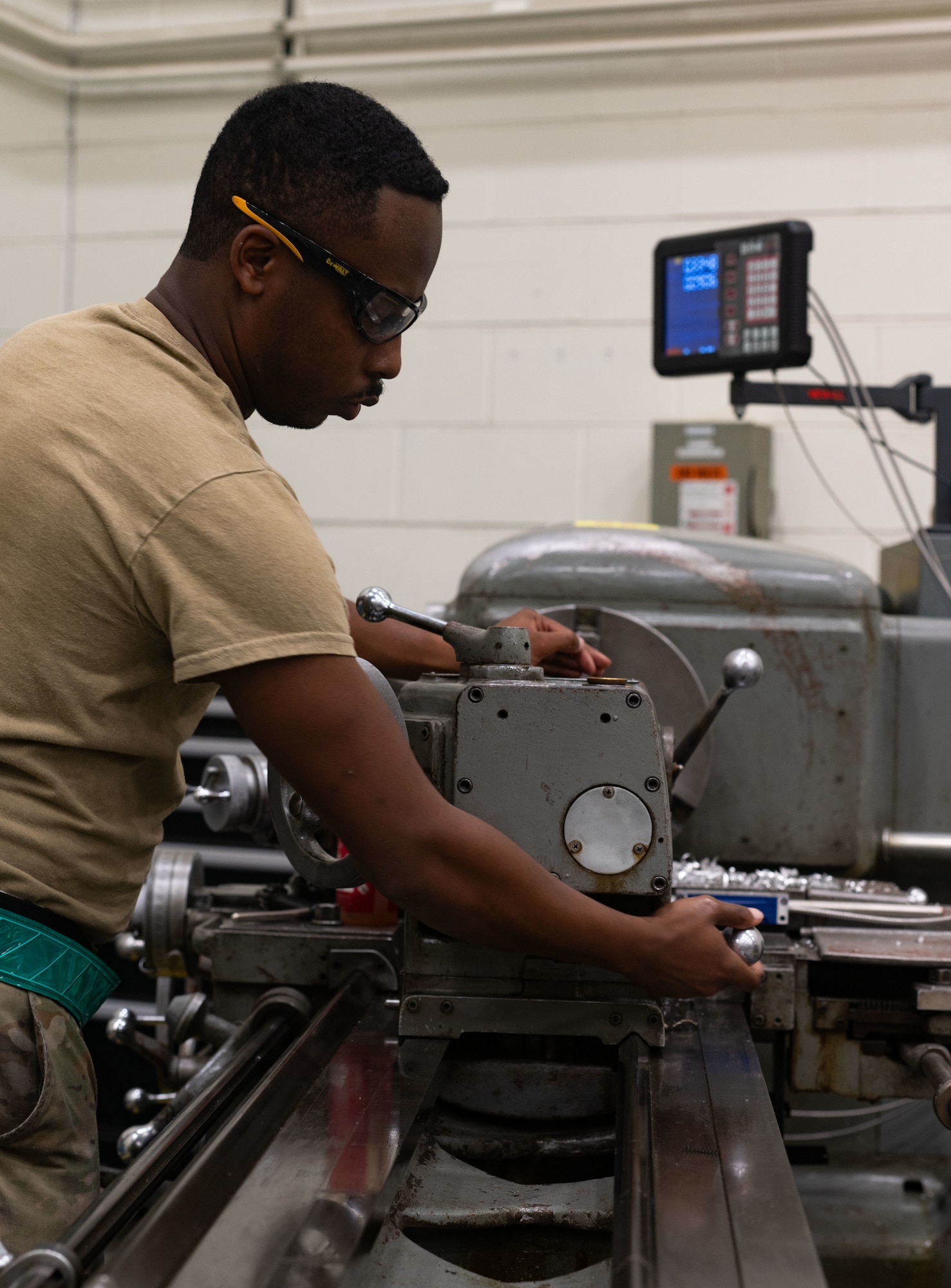 U.S. Air Force Senior Airman Jospeh Pullium, 305th Maintenance Squadron aircraft metals technology journeyman, operates a metal lathe at Joint Base McGuire-Dix-Lakehurst, N.J., Aug. 20, 2025. The lathe machine helps Airmen shape products by gradually shaving off pieces of metal. (U.S. Air Force photo by Airman Haeleigh Bayle)