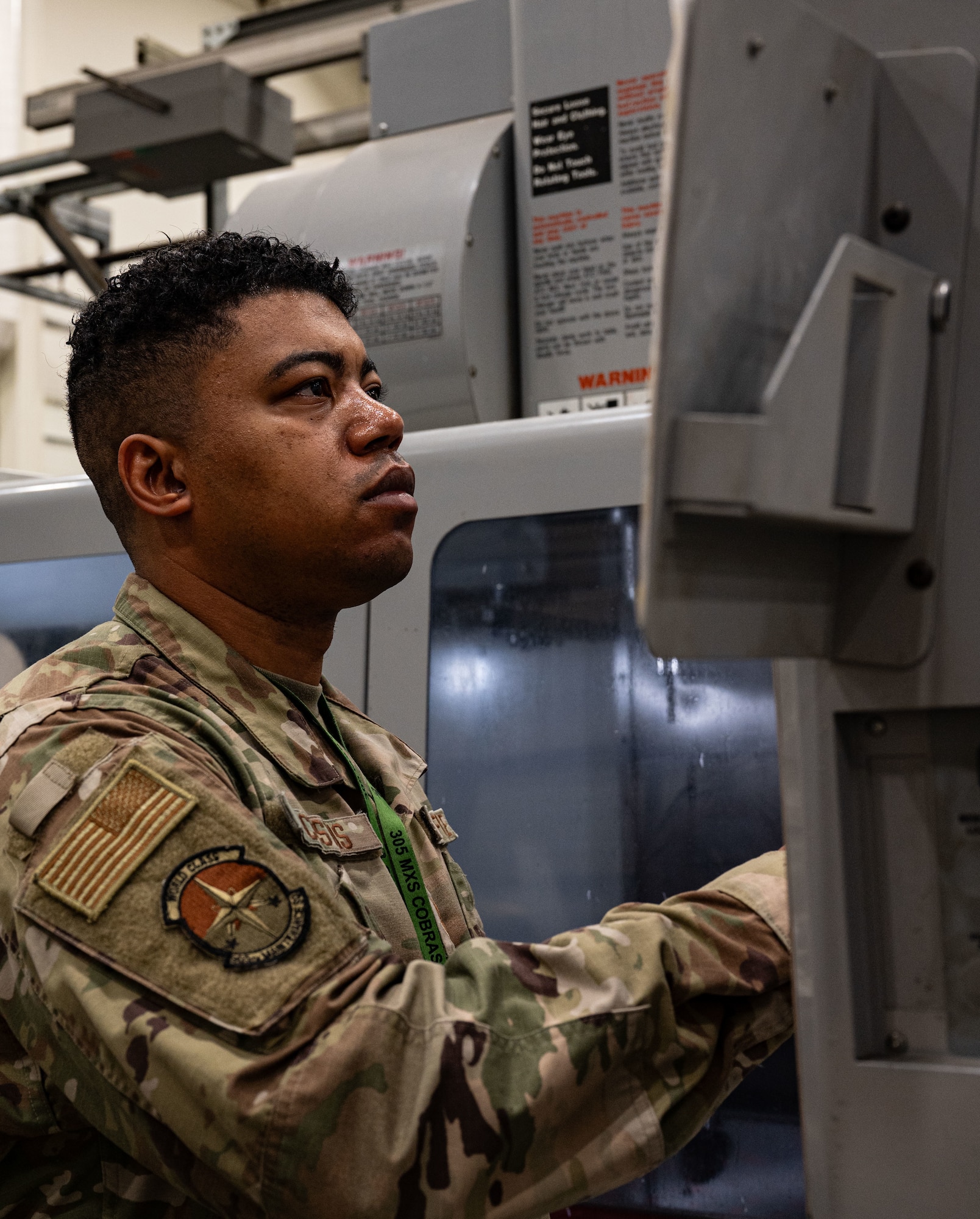 U.S. Air Force Tech. Sgt. Dontie Custis, 305th Maintenance Squadron noncommissioned officer in charge of Aircraft Metals Technology, programs the Computer Numeric Control machine at Joint Base McGuire-Dix-Lakehurst, N.J., Aug. 20, 2025. The CNC machine manufactured the Aileron C-channels needed to fix the KC-46A Pegasus at JB MDL. (U.S. Air Force photo by Airman Haeleigh Bayle)