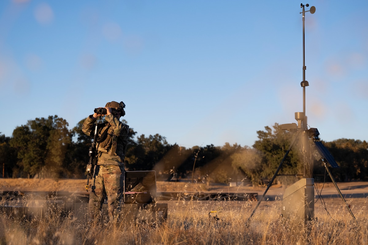Airman looks through binoculars