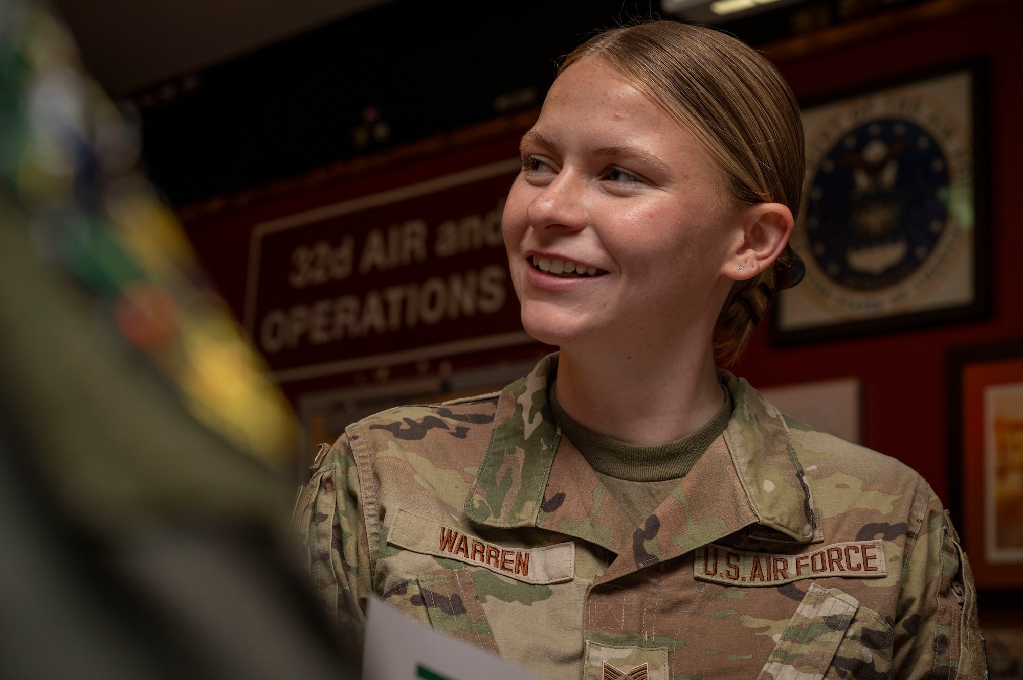 Staff Sgt. Eleanor Warren smiles while speaking to other Airmen