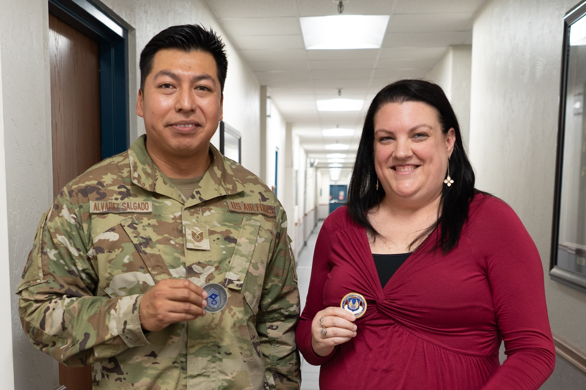 Two people pose with coins