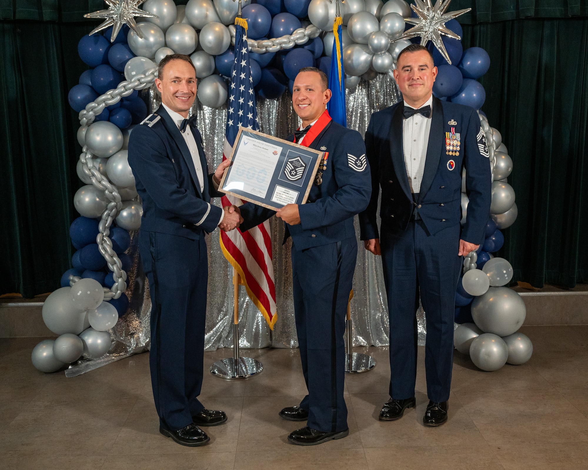 U.S. Air Force Col. Tyler Ellison, 47th Flying Training Wing (FTW) commander, left, and Chief Master Sgt. Erik Garza, 47th FTW command chief, right, present Technical Sgt. Jordan Arredondo, 47th Security Forces Squadron, center, with the Certificate of Induction at Laughlin Air Force Base, Texas, Aug. 22, 2025. The induction ceremony brings Airmen together to celebrate the achievement of entering the realm of senior enlisted leaders. (U.S. Air Force photo by Staff Sgt. Nicholas Larsen)