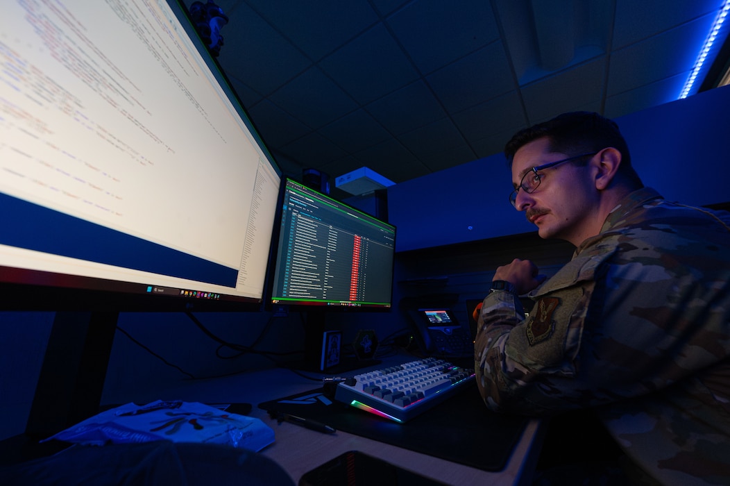 U.S. Air Force Senior Airman Nicholas Agriesti, 509th Communications Squadron cyber readiness technician, looks through code on his computer at Whiteman Air Force Base, Missouri, Aug. 11, 2025.