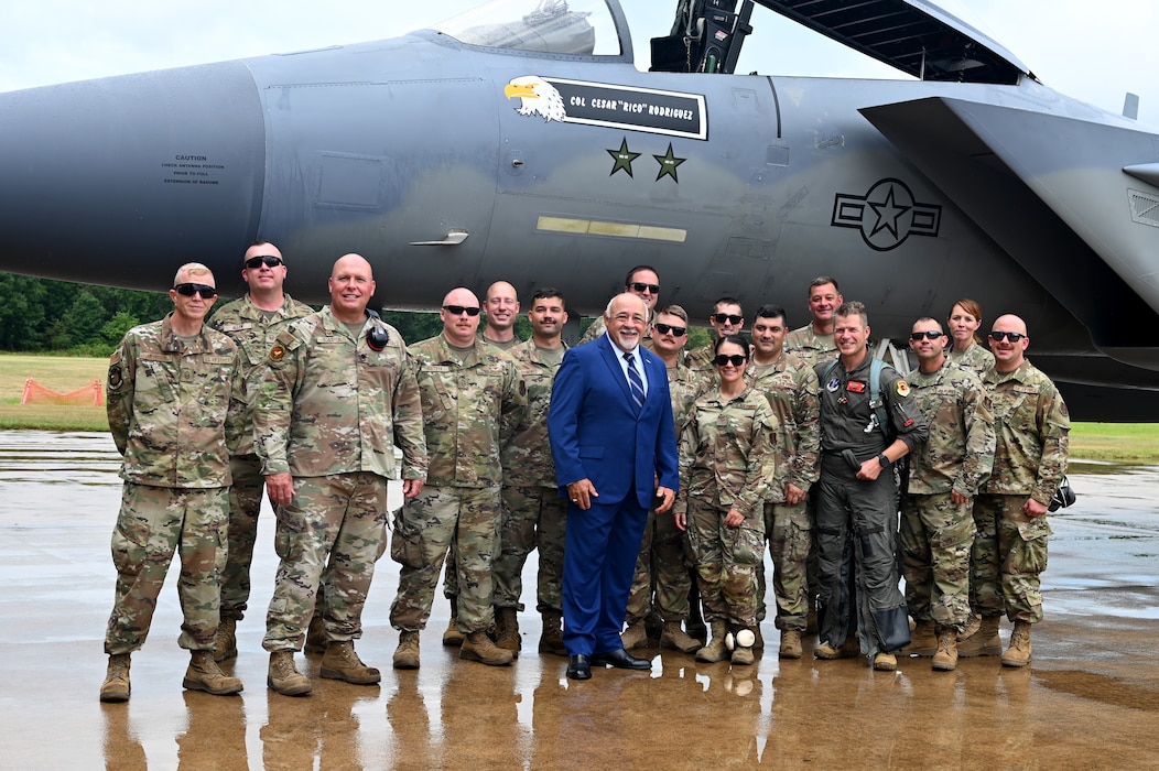 People pose next to an F15