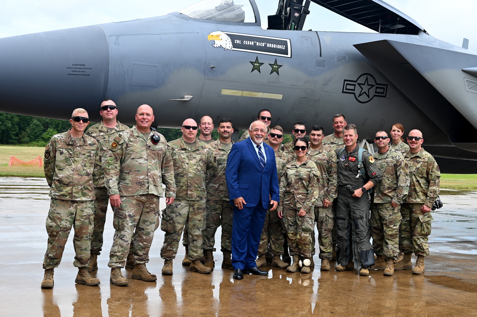 People pose next to an F15
