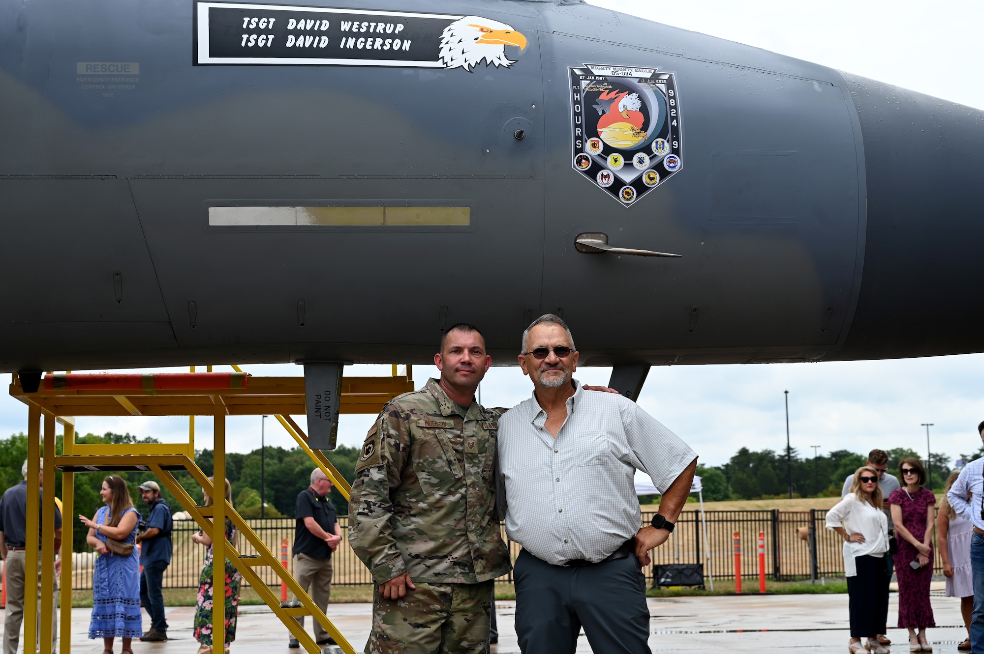 People pose for a picture next to an aircraft