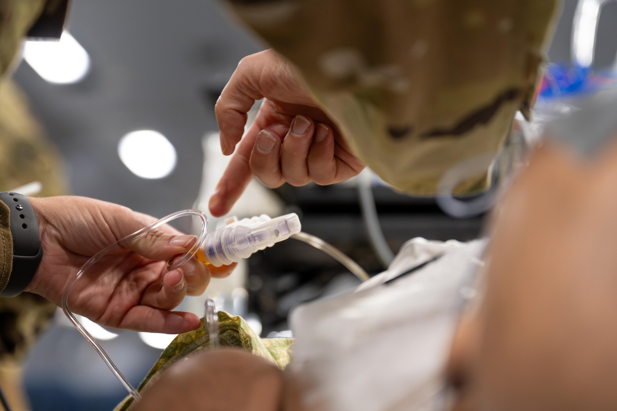 Airmen secure medical tubing on a medical simulation mannequin during the “Vapor Trails” exercise at Kelly Field, San Antonio, Texas, Aug. 21, 2025. The training scenario allowed aeromedical evacuation and critical care air transport teams to practice patient care procedures in a simulated in-flight environment aboard a KC-46 Pegasus aircraft. (U.S. Air Force photo by Airman 1st Class Lauren Torres)