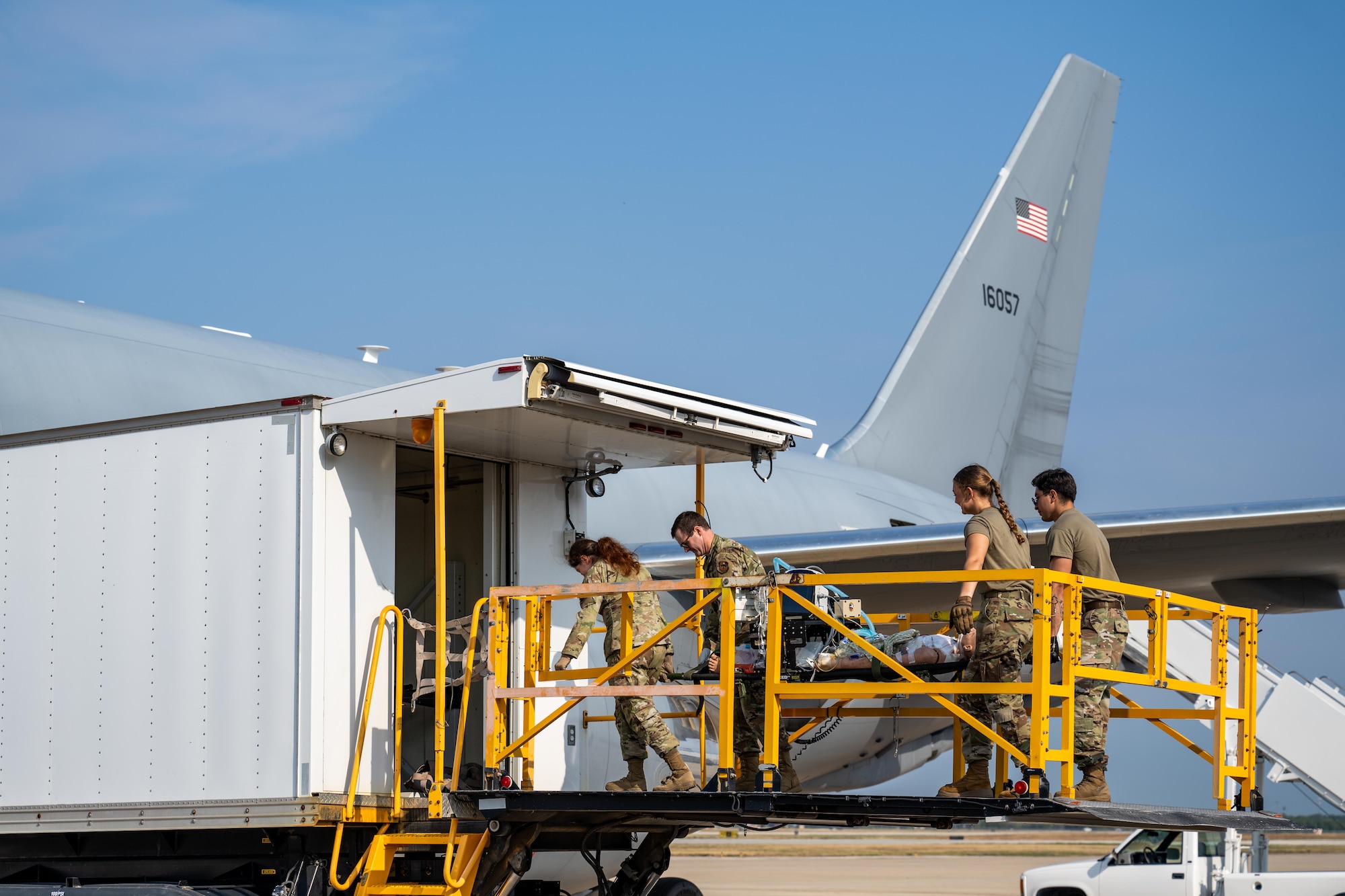 Airmen from the 59th Medical Wing at Joint Base San Antonio, carry a medical simulation mannequin onto a KC-46 Pegasus aircraft at Kelly Field, San Antonio, Texas, Aug. 21, 2025. The mannequin was used to simulate a critically ill patient, giving aeromedical evacuation and critical care air transport teams the opportunity to practice patient movement and in-flight care procedures during the “Vapor Trails” exercise.  (U.S. Air Force photo by Airman 1st Class Lauren Torres)