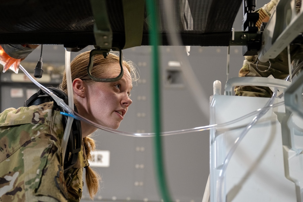U.S. Air Force Staff Sgt. Nicole Small, Tinker Air Force Base 137th Aeromedical Evacuation Squadron aeromedical evacuation technician, sets up in-flight medical equipment on a KC-46 Pegasus aircraft at Kelly Airfield, San Antonio, Texas, Aug. 21, 2025. The equipment was prepared to support simulated patient care, allowing medical teams to train alongside aircrew during the “Vapor Trails” exercise. (U.S. Air Force photo by Airman 1st Class Lauren Torres)