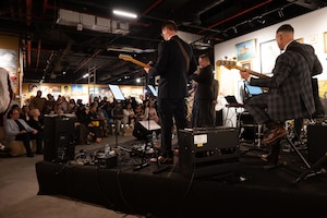 The U.S. Air Force Central Band plays for a crowd during a  jazz concert within the U.S. Central Command area of responsibility, Aug. 19, 2025. The band is the official musical unit of U.S. Air Forces Central Command (AFCENT), composed of active-duty Air Force musicians deployed from various bases worldwide. (U.S. Air Force photo by Senior Airman Dieondiere Jefferies)