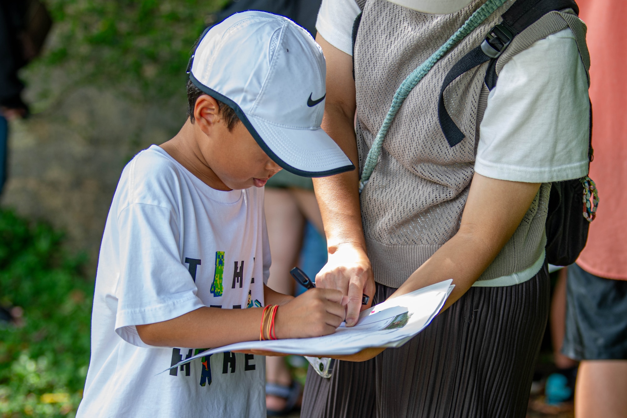 A local resident writes in a worksheet during a historical site tour of Kadena Air Base, Japan, Aug. 13, 2025.
