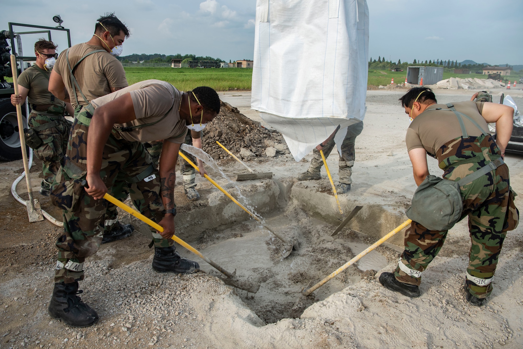 U.S. Air Force Airmen assigned to the 51st Civil Engineer Squadron mix water and quick setting concrete to replace an area of unusable concrete while conducting rapid airfield damage repair during exercise Ulchi Freedom Shield 25 at Osan Air Base, Republic of Korea, Aug. 20, 2025