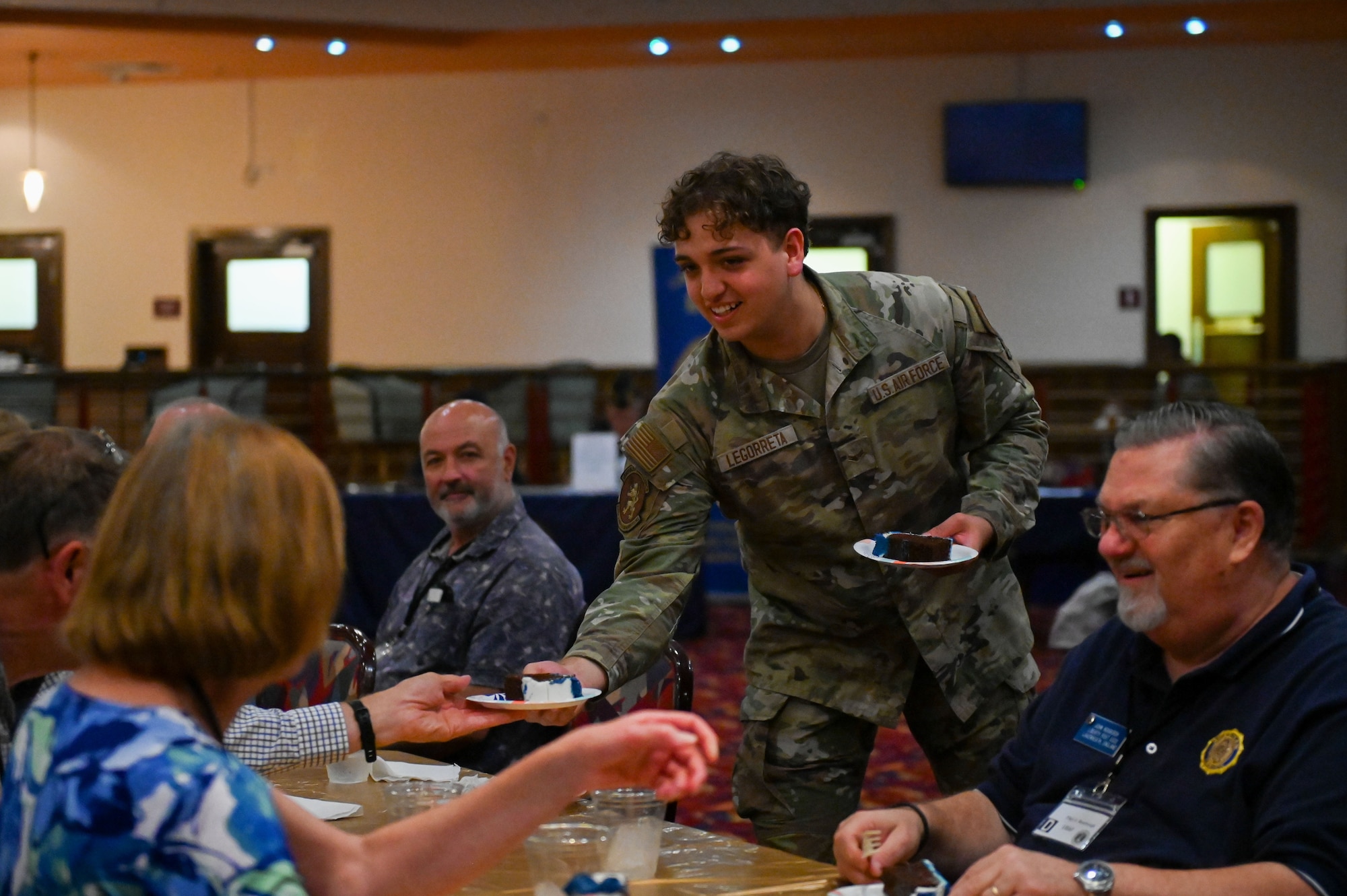 U.S. Air Force Airman 1st Class Sergio Legorreta, 100th Logistics Readiness Squadron aircraft parts store journeyman, assists retired service members during the 2025 Retiree Appreciation Day at RAF Mildenhall, England, Aug. 15, 2025.