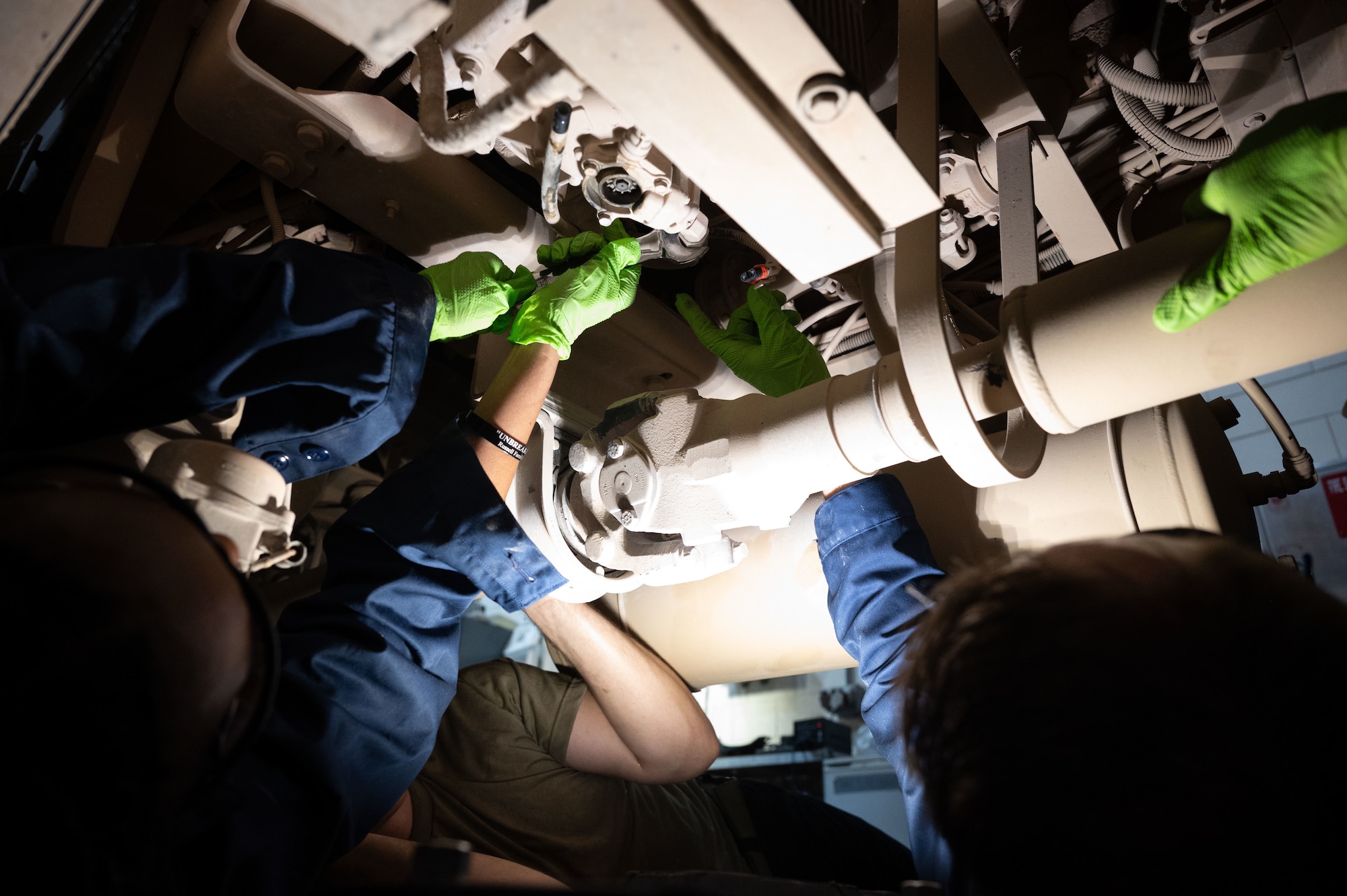 The 379th Air Expeditionary Wing command team uses wrenches to work on a truck during a “dirty jobs” unit immersion within the U.S. Central Command area of responsibility, Aug. 21, 2025. The 379th Expeditionary Logistics Readiness Squadron vehicle maintenance shop keeps fire trucks, fuel tankers, and heavy equipment mission-ready through routine maintenance, repairs and inspections. (U.S. Air Force photo by Senior Airman Dieondiere Jefferies)