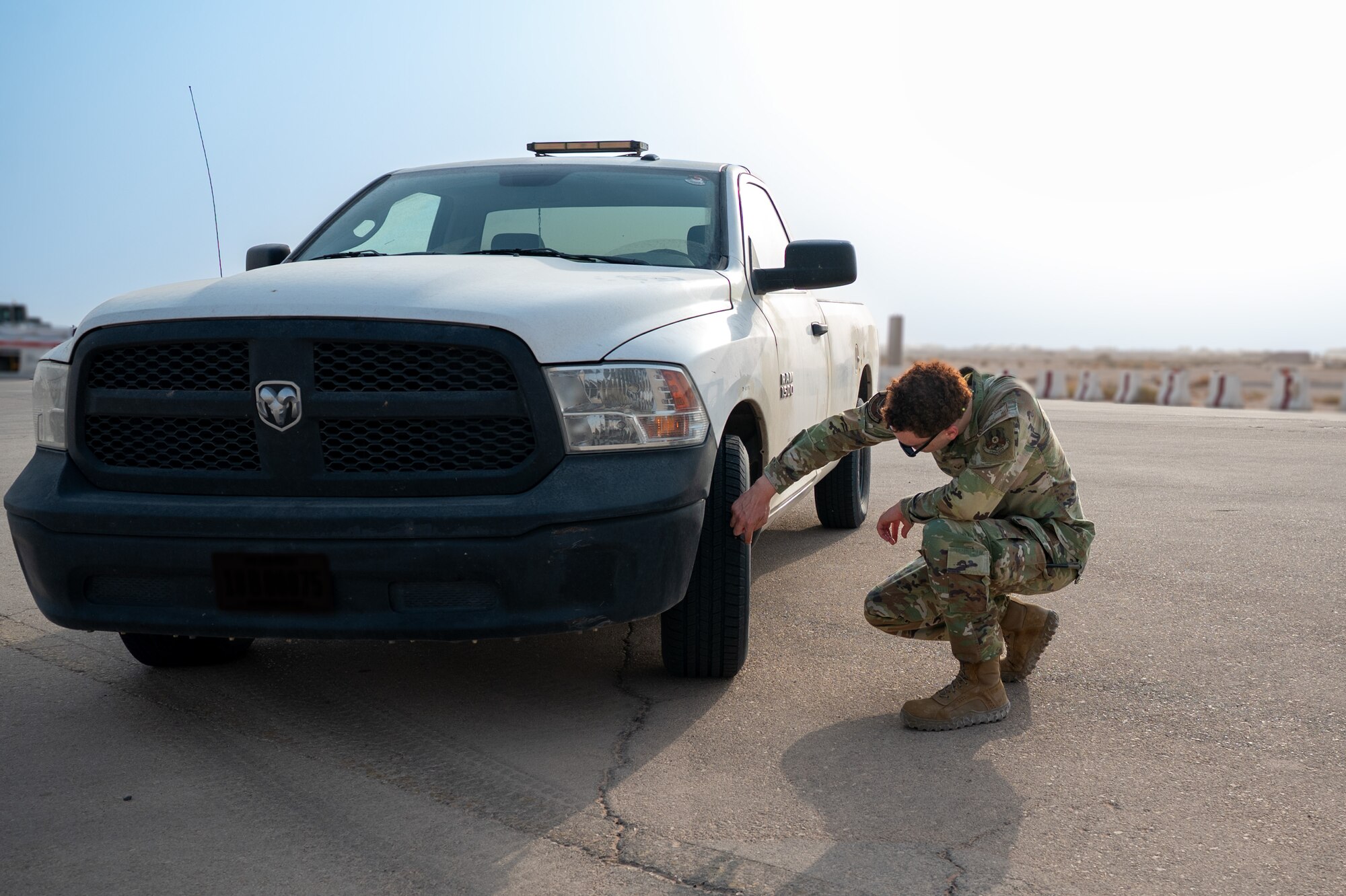 Airman inspects the tires of a vehicle on the flight line