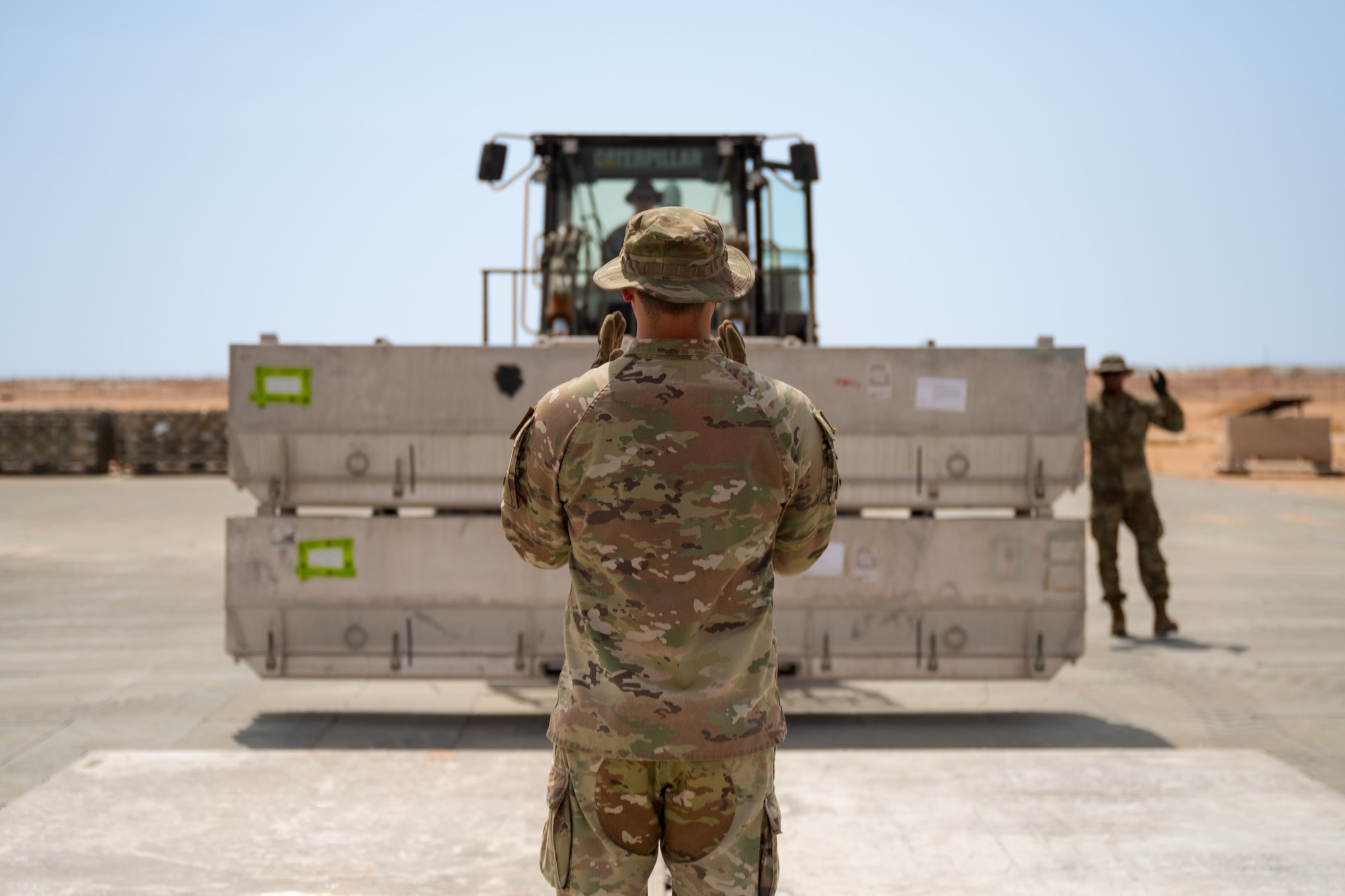 Airman directs a forklift carrying cargo