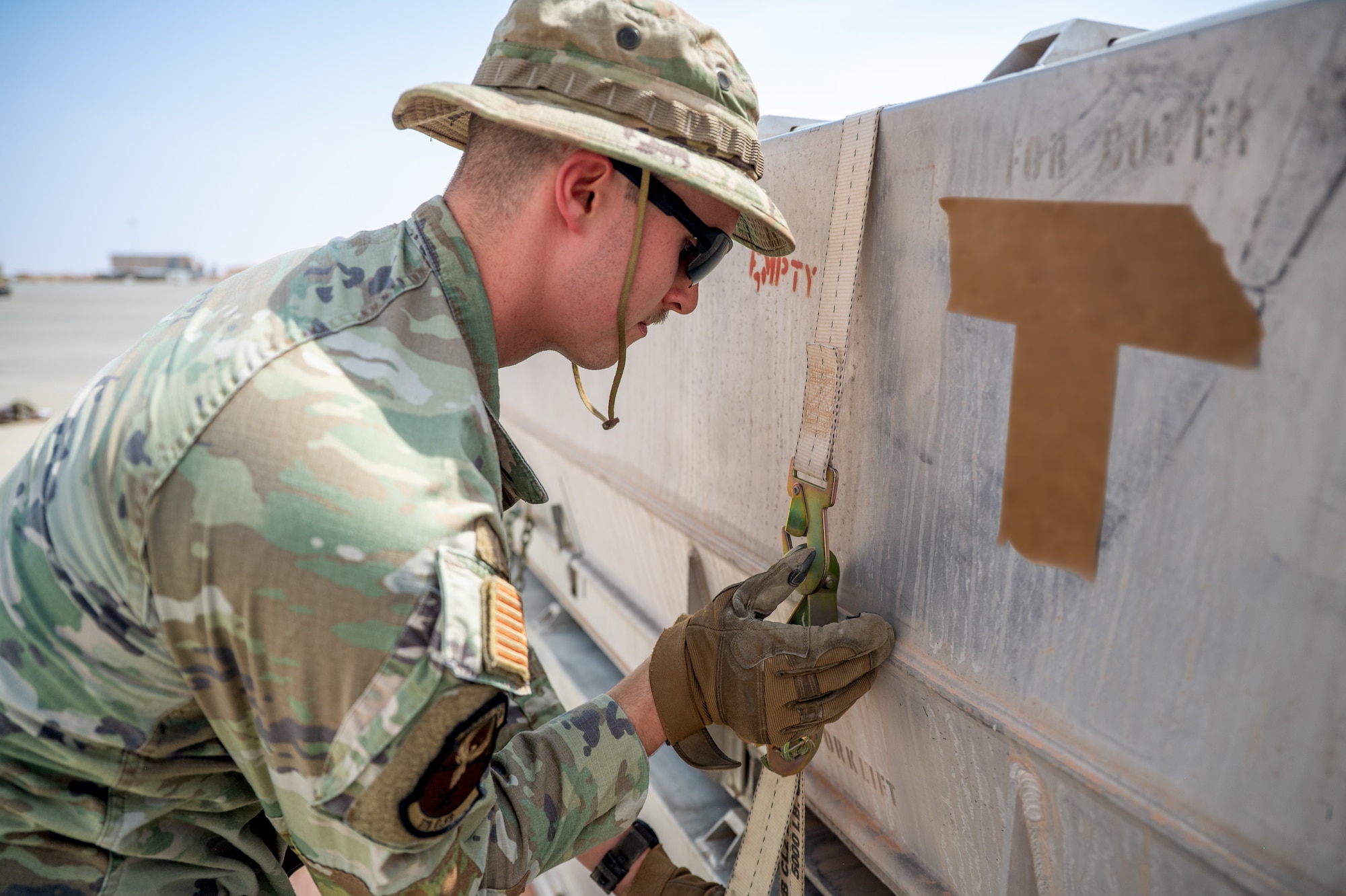 Airman secures strap to cargo