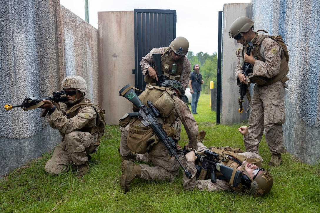 U.S. Marines with II Marine Expeditionary Force Support Battalion, treat a simulated casualty during the Outdoor Infantry Immersion Trainer at Camp Lejeune, North Carolina, Aug. 20, 2025. The O-IIT provides a realistic training environment, allowing Marines to sharpen decision making, improve unit cohesion, and prepare for operational challenges in urban environments. (U.S. Marine Corps photo by Sgt. Jacquilyn Davis)