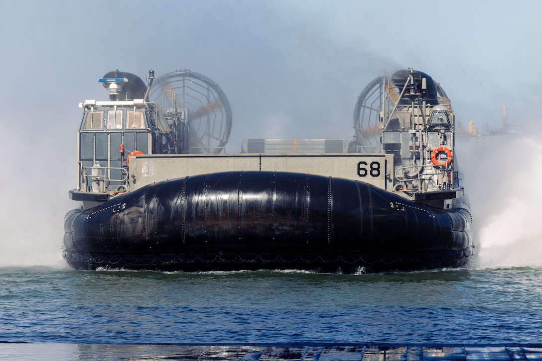 A U.S. Navy Landing Craft Air Cushion transports 22nd Marine Expeditionary Unit (Special Operations Capable) artillery ammunition to the San Antonio-class amphibious transport dock ship USS Fort Lauderdale (LPD 28), Iwo Jima Amphibious Ready Group, while in port at Naval Base Norfolk, Virginia, August 22, 2025. Equipment and personnel were transferred between ships within the IWO ARG in support of the 22nd MEU (SOC)’s regularly scheduled deployment. (U.S. Marine Corps photo by Lance Cpl. Kyle Baskin)