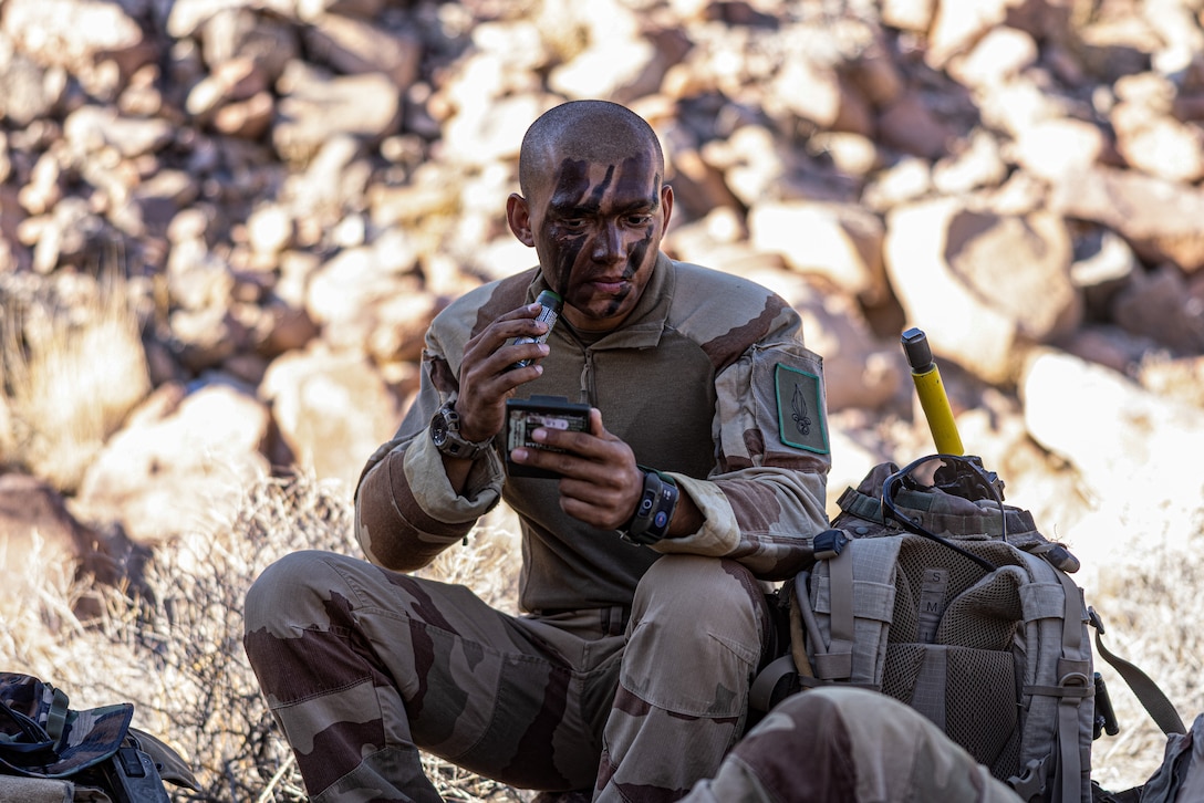 A French Legionnaire with 2nd Foreign Infantry Regiment, 6th Light Armored Brigade applies camouflage paint for Marine Air Ground Task Force Warfighting Exercise during Service Level Training Exercise 4-25, at Marine Corps Air-Ground Combat Center, Twentynine Palms, California, Aug. 18, 2025. SLTE 4-25 is designed to be a challenging, realistic training environment that produces combat-ready forces capable of operating as an integrated Marine Air Ground Task Force across all domains of military operations. (U.S. Marine Corps photo by Lance Cpl. Judith Ann Lazaro)