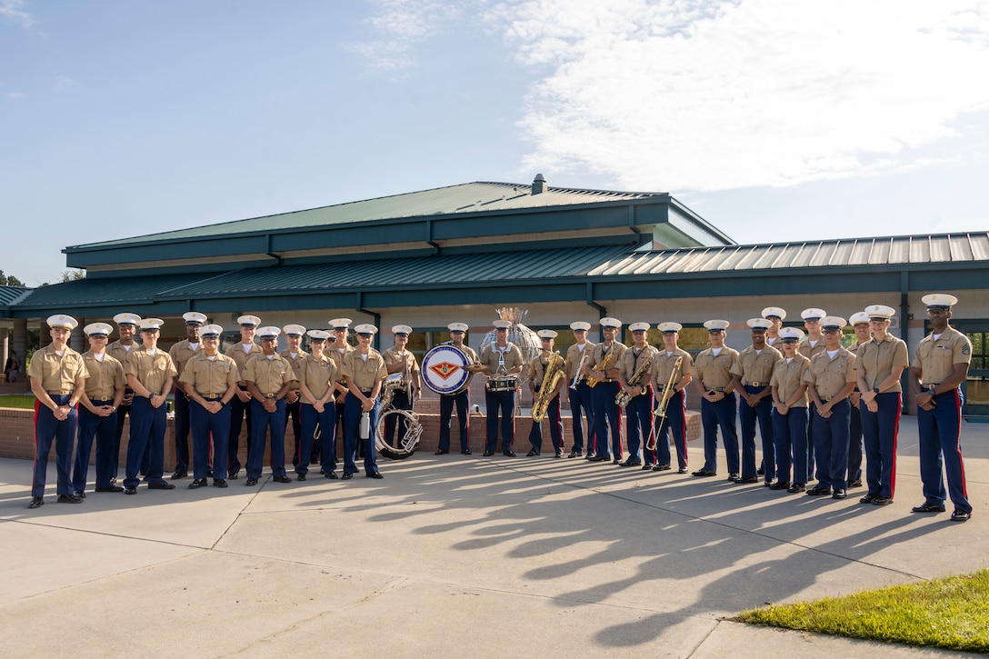 U.S. Marines with Combat Logistics Battalion 22, Combat Logistics Regiment 27, 2nd Marine Logistics Group, and the 2nd Marine Aircraft Wing Band pose for a photo at Carolina Forest Elementary School in Jacksonville, North Carolina, Aug. 25, 2025. CLB-22 and the 2nd MAW Band welcomed students of Carolina Forest Elementary back for the 2025-2026 school year to build morale and enhance community relations. (U.S. Marine Corps photo by Lance Cpl. Isabella Ramos)