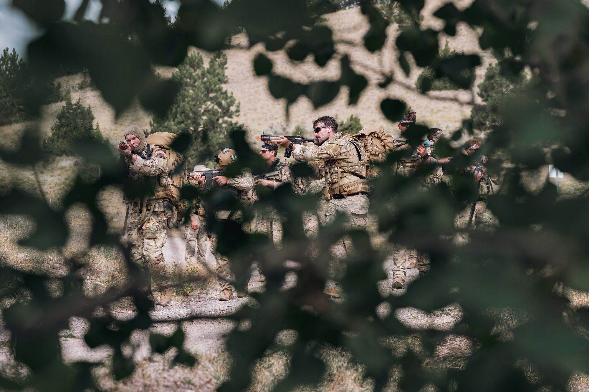 A squadron of Airmen walk with their weapons pointed up.