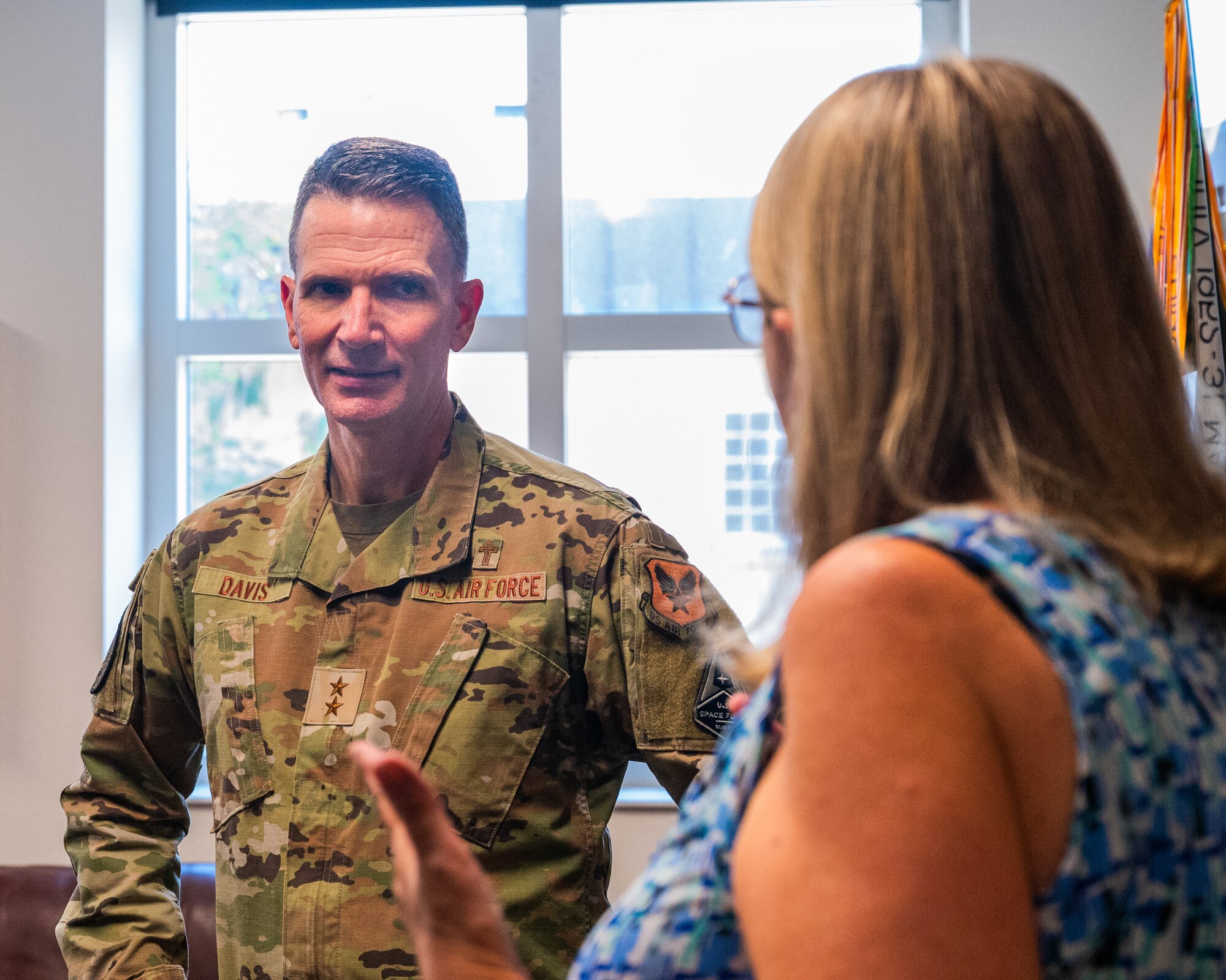 U.S. Air Force Maj. Gen. Trent Davis, Department of the Air Force chief of chaplains, learns about the 310th Fighter Squadron’s history from Jan Cutrona, 310th Fighter Squadron unit program coordinator, during a squadron visit, Aug. 22, 2025, at Luke Air Force Base, Arizona.