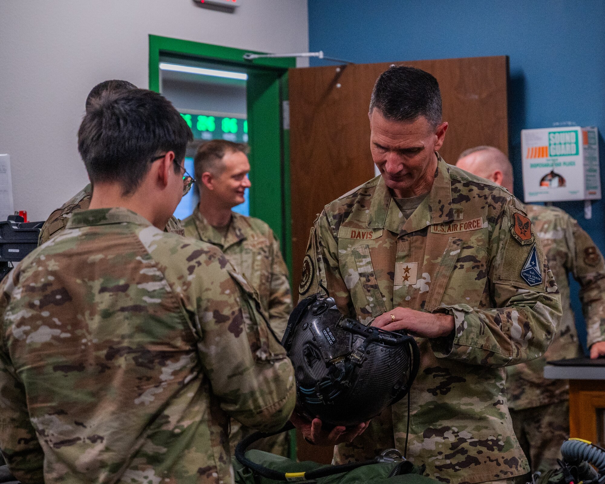 U.S. Air Force Maj. Gen. Trent Davis, Department of the Air Force chief of chaplains, learns about F-35A Lighting II equipment from Airman 1st Class Ethan Christobal, 56th Operational Support Squadron aircrew flight equipment specialist, during a squadron visit, Aug. 22, 2025, at Luke Air Force Base, Arizona.