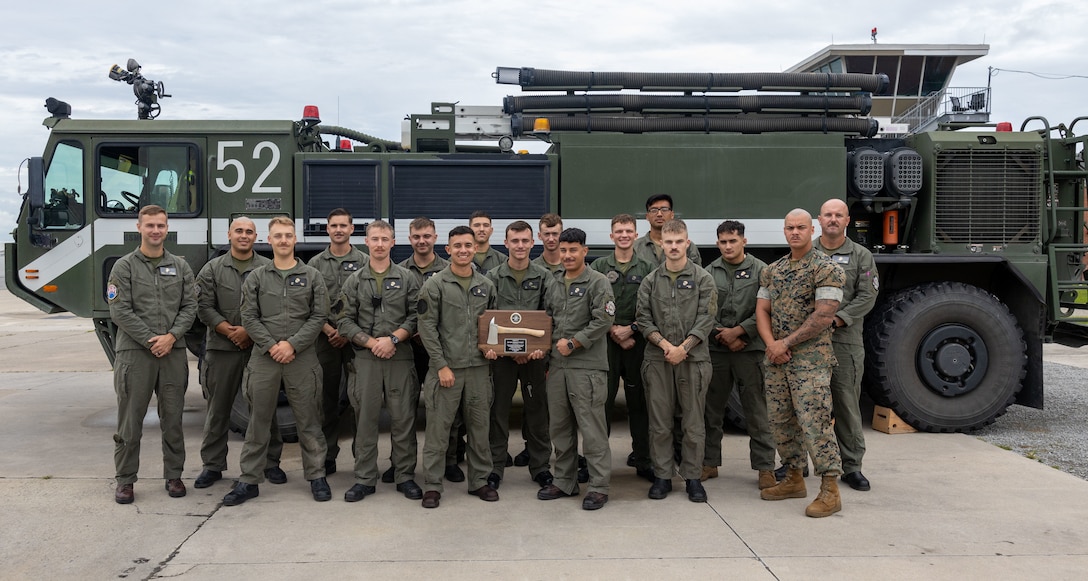 U. S. Marines assigned to Aircraft Rescue and Fire Fighting with Headquarters and Headquarters Squadron, Marine Corps Air Station Cherry display the plaque awarded for earning the Medium Fire Department of the Year Award 2024 at MCAS Cherry Point, North Carolina, Aug. 11, 2025. The joint award recognized Cherry Point Fire & Emergency Services and ARFF for providing excellent fire, EMS and ARFF services for MCAS Cherry Point and its surrounding areas.