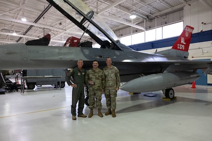 From left, U.S. Air Force Maj. Gen. Gregory Kreuder, commander, 19th Air Force, Tech. Sgt. Andrew Quiroz, 162nd Aircraft Maintenance Squadron avionics technician, and Chief Master Sgt. Keith Scott, command chief 19th Air Force, gather for a photo  at Morris Air National Guard Base, Ariz., Aug. 19, 2025. Quiroz was recognized for his contributions to the maintenance of Aircraft 379. Aircraft 379, critical for student pilot training, underwent depot-level maintenance, averting a year long wait and saving millions of dollars. This initiative exemplifies the 162nd Wing’s commitment to efficient resource management in support of the 19th Air Force mission to produce the next generation of aviators. (U.S. Air National Guard photo by Staff Sgt. Guadalupe Beltran)