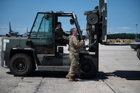 Staff Sgt. Brendan Brack, an air cargo worker with the 157th Logistics Readiness Squadron, assists Senior Airman Rachel Pincince, an air transportation specialist with the 157th LRS, in lifting a cargo pallet into a KC-46 Pegasus on the flight line August 15, 2025, at Pease Air National Guard Base, New Hampshire.