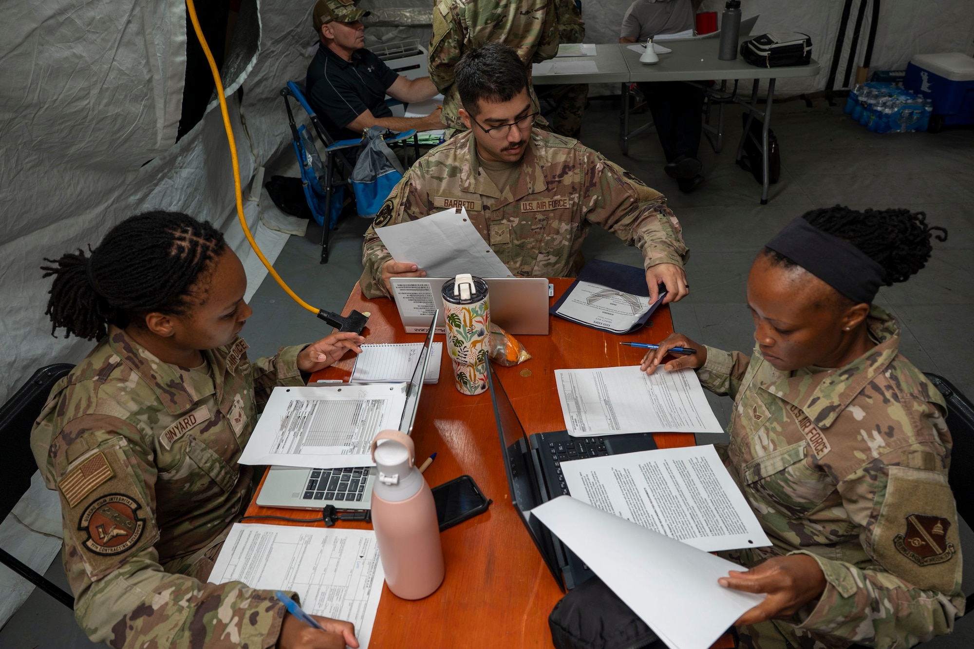 From left to right, U.S. Air Force Senior Airmen Kaiya Ginyard, Johnny Barreto, and Anida Dublin, all with the 11th Contracting Squadron, review contract documents at Joint Base-Anacostia-Bolling, Washington, D.C., Aug. 19, 2025. The team processed 40 scenarios during a three-day exercise to ensure deployment capability. (U.S. Air Force photo by Staff Sgt. Jordan Powell)