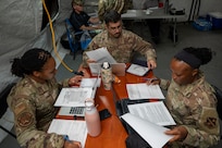 From left to right, U.S. Air Force Senior Airmen Kaiya Ginyard, Johnny Barreto, and Anida Dublin, all with the 11th Contracting Squadron, review contract documents at Joint Base-Anacostia-Bolling, Washington, D.C., Aug. 19, 2025. The team processed 40 scenarios during a three-day exercise to ensure deployment capability. (U.S. Air Force photo by Staff Sgt. Jordan Powell)