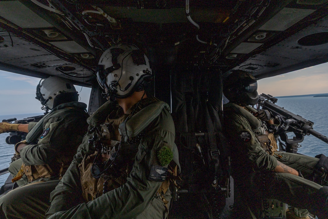U.S. Marine Corps Gunnery Sgt. Jose Espitia, left, a flight-line mechanic, Gunnery Sgt. JoshuaJohn Navarro, center, an airframes mechanic and Sgt. Angel Hernandez, right, a crew chief with Marine Light Attack Helicopter Squadron 775, Marine Aircraft Group 41, 4th Marine Aircraft Wing, after successfully conducting a simulated visit, board, search and seizure operation for Training Exercise Northern Strike at Camp Grayling, Michigan, Aug. 7, 2025. Northern Strike is designed to validate readiness of a Joint Reserve force to cover unique Marine Corps Reserve capabilities and support to active components on a large scale. (U.S. Marine Corps photo by Cpl. Aaron TorresLemus)