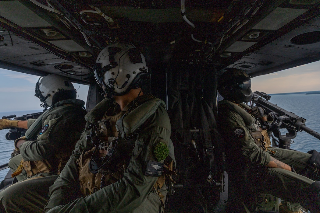 U.S. Marine Corps Gunnery Sgt. Jose Espitia, left, a flight-line mechanic, Gunnery Sgt. JoshuaJohn Navarro, center, an airframes mechanic and Sgt. Angel Hernandez, right, a crew chief with Marine Light Attack Helicopter Squadron 775, Marine Aircraft Group 41, 4th Marine Aircraft Wing, after successfully conducting a simulated visit, board, search and seizure operation for Training Exercise Northern Strike at Camp Grayling, Michigan, Aug. 7, 2025. Northern Strike is designed to validate readiness of a Joint Reserve force to cover unique Marine Corps Reserve capabilities and support to active components on a large scale. (U.S. Marine Corps photo by Cpl. Aaron TorresLemus)