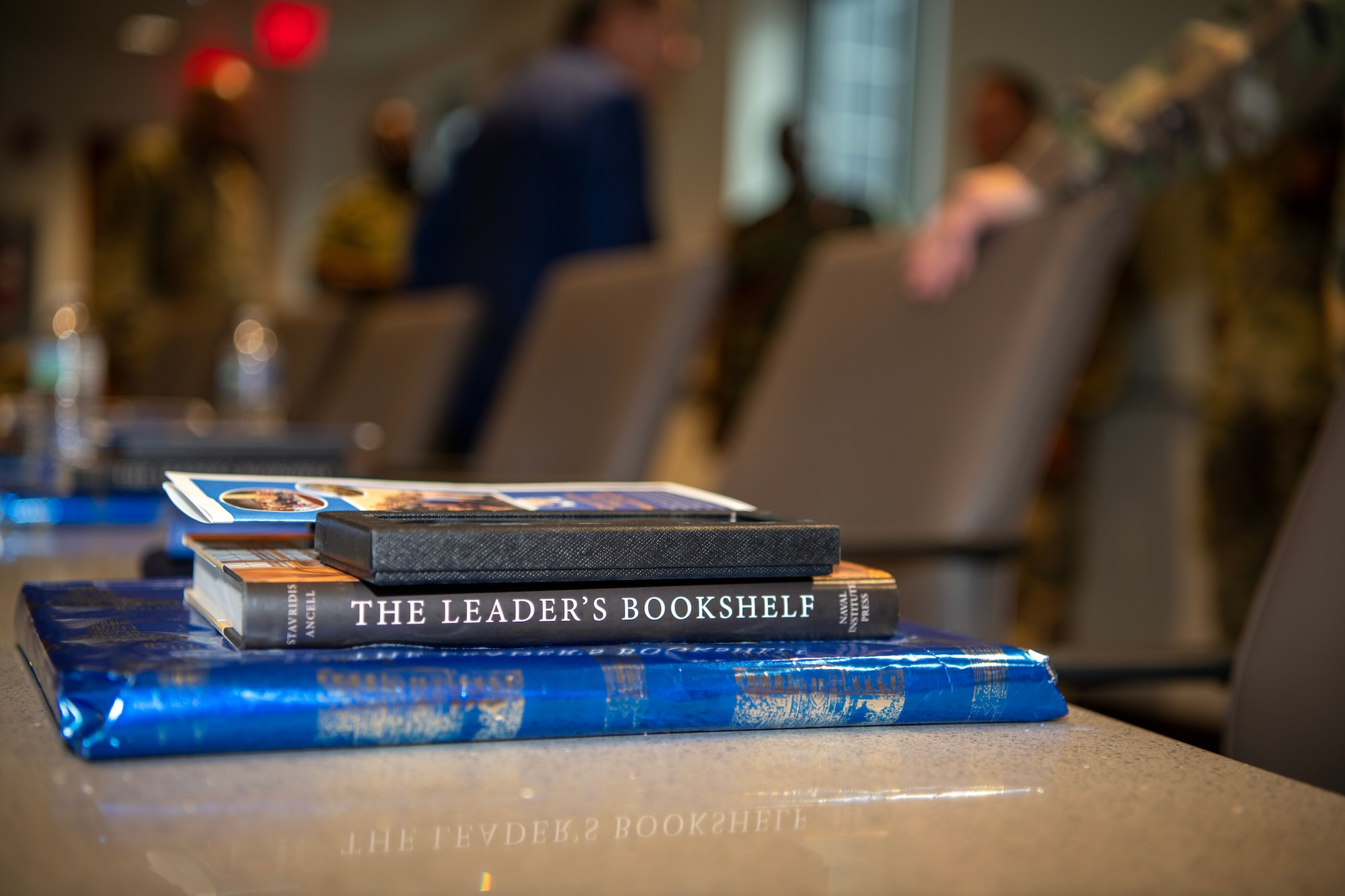 Retired Air Force Maj. Gen. Charlie Dunlap, Jr, provides books to North Carolina Air National Guard judge advocates and state partnership program attorneys during his briefing at Duke University’s School of Law, July 31, 2025.