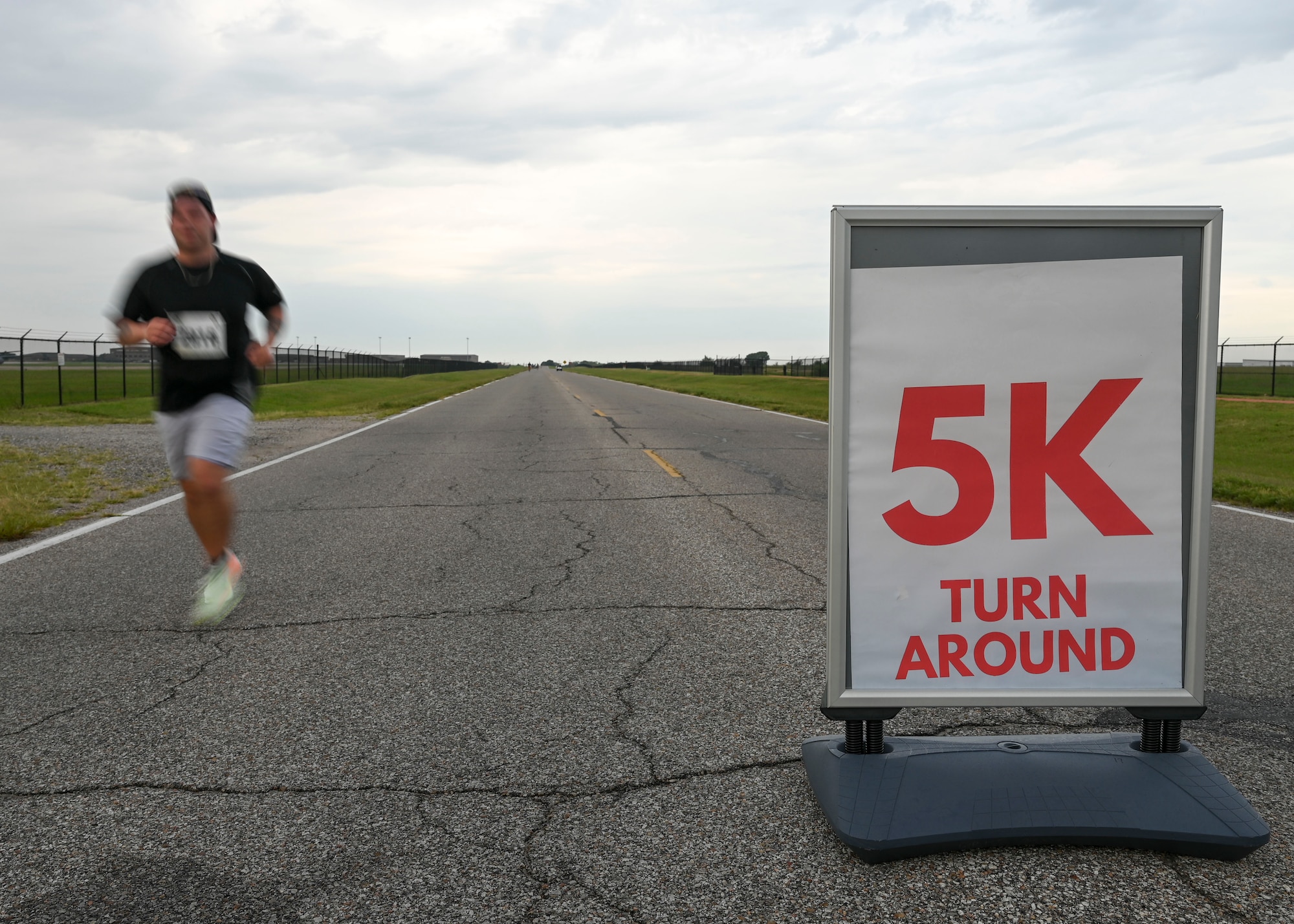 A man runs past a sign that says "5K turn around"