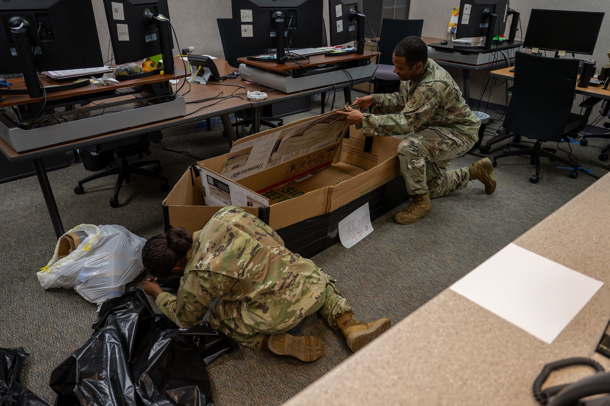 22nd Operations Support Squadron Airmen build a boat for a cardboard regatta race at McConnell Air Force Base, Kansas, Aug. 19, 2025. Each flight from the OSS was challenged with building boats out of cardboard boxes to later compete in a race in the base indoor pool. (U.S. Air Force photo by Airman 1st Class Paula Arce)