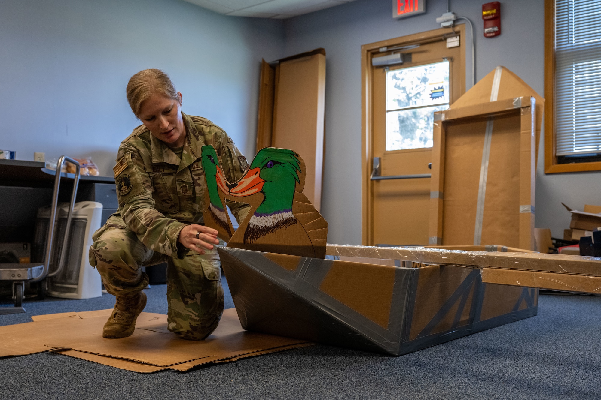 Senior Master Sgt. Melissa Healy, 22nd Operations Support Squadron weather flight chief, builds a mallard-themed boat for McConnell’s cardboard regatta race at McConnell Air Force Base, Kansas, Aug. 21, 2025. McConnell’s weather flight’s mascot is the mallard. (U.S. Air Force photo by Airman 1st Class Paula Arce)