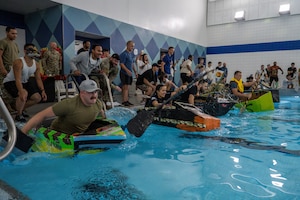 Flights from the 22nd Operations Support Squadron compete in McConnell’s cardboard race regatta at McConnell Air Force Base, Kansas, Aug. 22, 2025. Participants were permitted cardboard, tape and paint for building their competition boats. (U.S. Air Force photo by Airman 1st Class Paula Arce)