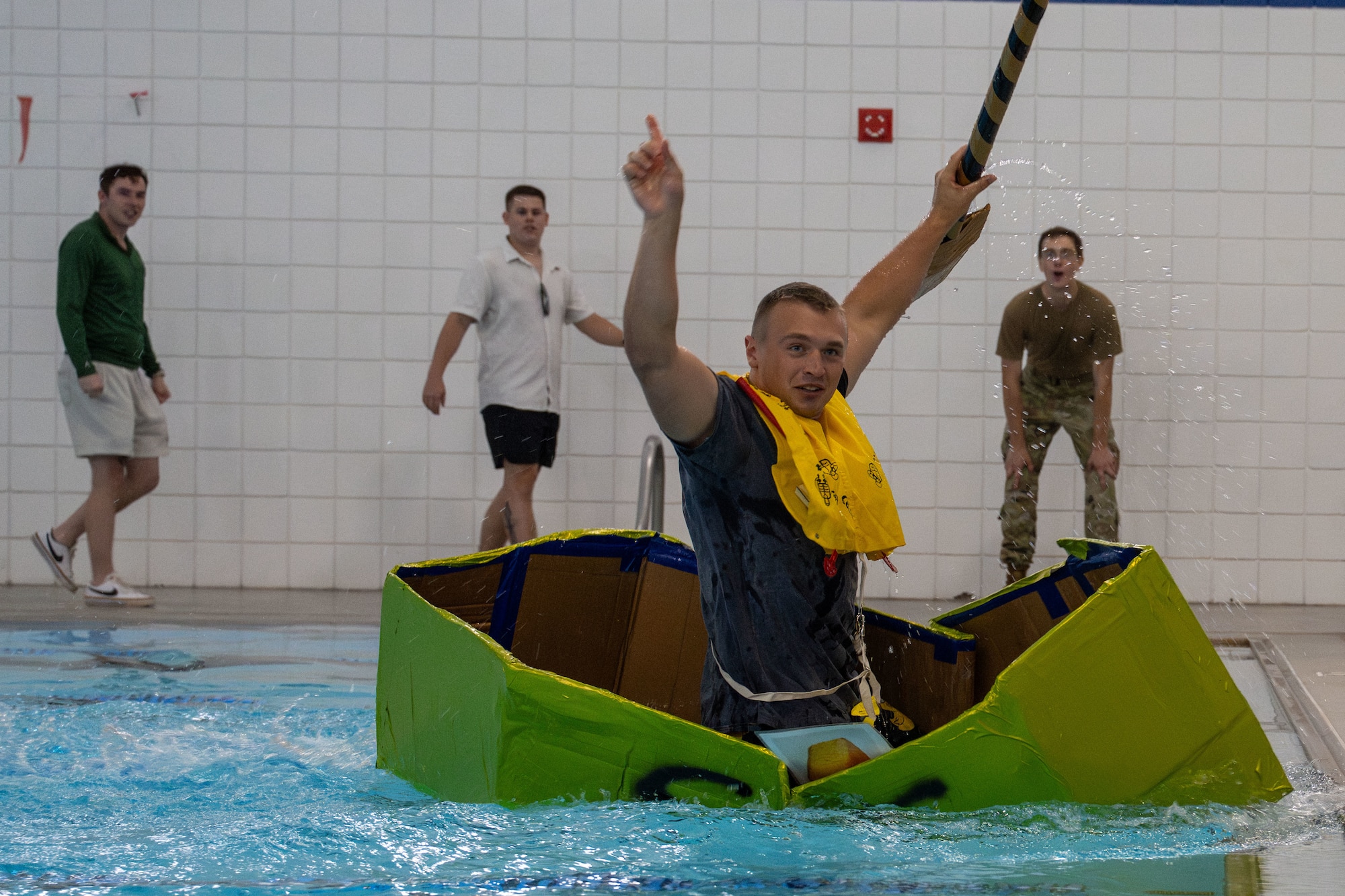 Airman Jakob Weichers, 22nd Operations Support Squadron aircrew flight equipment specialist, celebrates after winning McConnell’s cardboard race regatta at McConnell Air Force Base, Kansas, Aug. 22, 2025. Morale activities, such as boat races, foster an environment of collaboration, communication and group problem solving. (U.S. Air Force photo by Airman 1st Class Paula Arce)