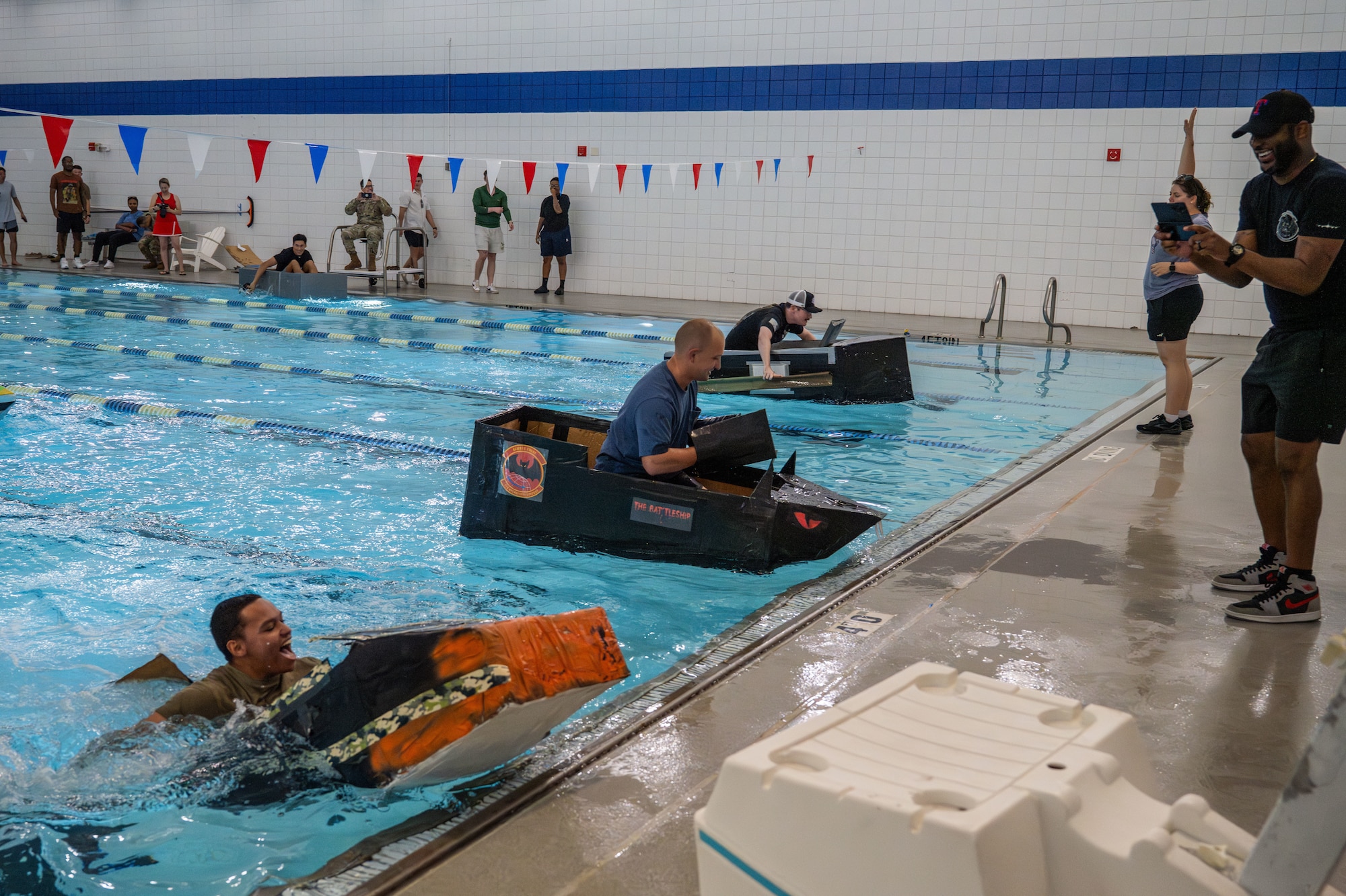 Flights from the 22nd Operations Support Squadron compete in McConnell’s cardboard race regatta at McConnell Air Force Base, Kansas, Aug. 22, 2025. Participants were permitted cardboard, tape and paint for building their competition boats. (U.S. Air Force photo by Airman 1st Class Paula Arce)