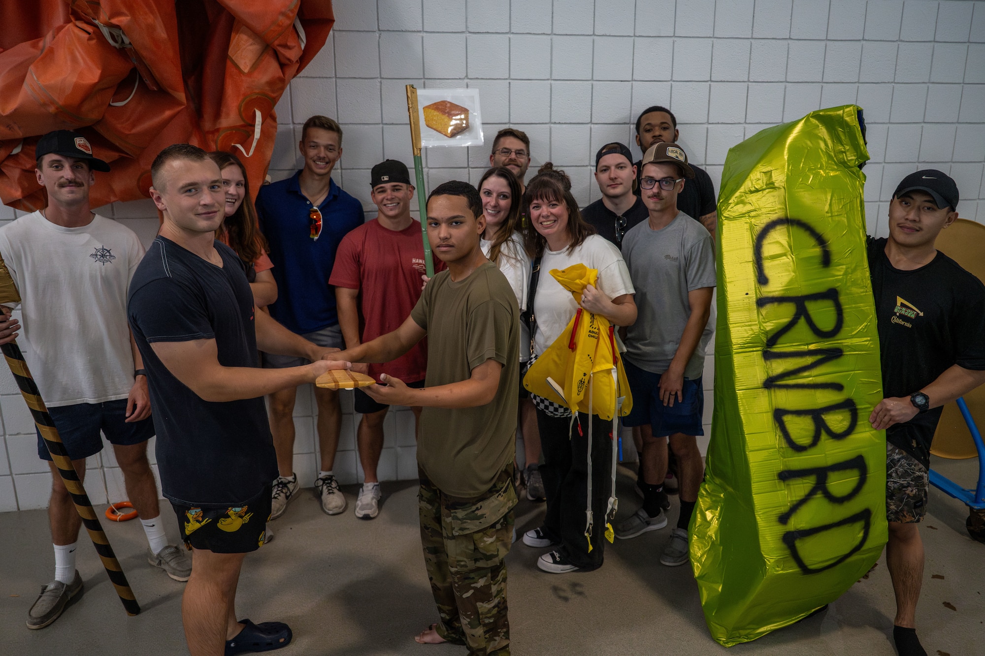 Airmen from the 22nd Operations Support Squadron pose after competing in McConnell’s cardboard race regatta at McConnell Air Force Base, Kansas, Aug. 22, 2025. Aircrew flight equipment took first place in the boat race and the boat appearance competition. (U.S. Air Force photo by Airman 1st Class Paula Arce)