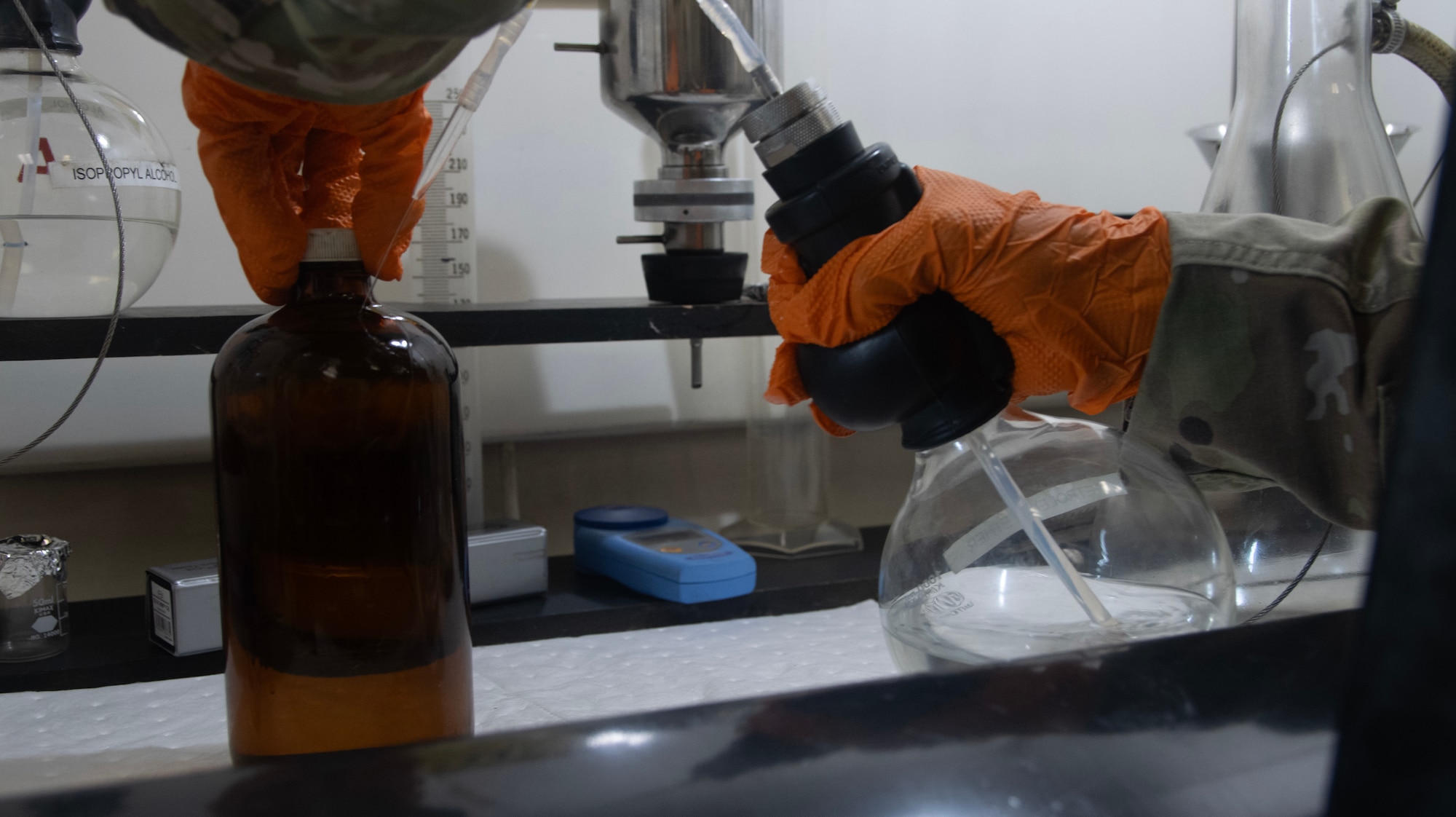 A fuels laboratory technician assigned to the 1st Special Operations Wing rinses samples  with petroleum ether to remove residual fuel and particulates at Hurlburt Field, Florida, Aug. 7, 2025.